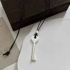 Long cord necklace with matte silver key pendant