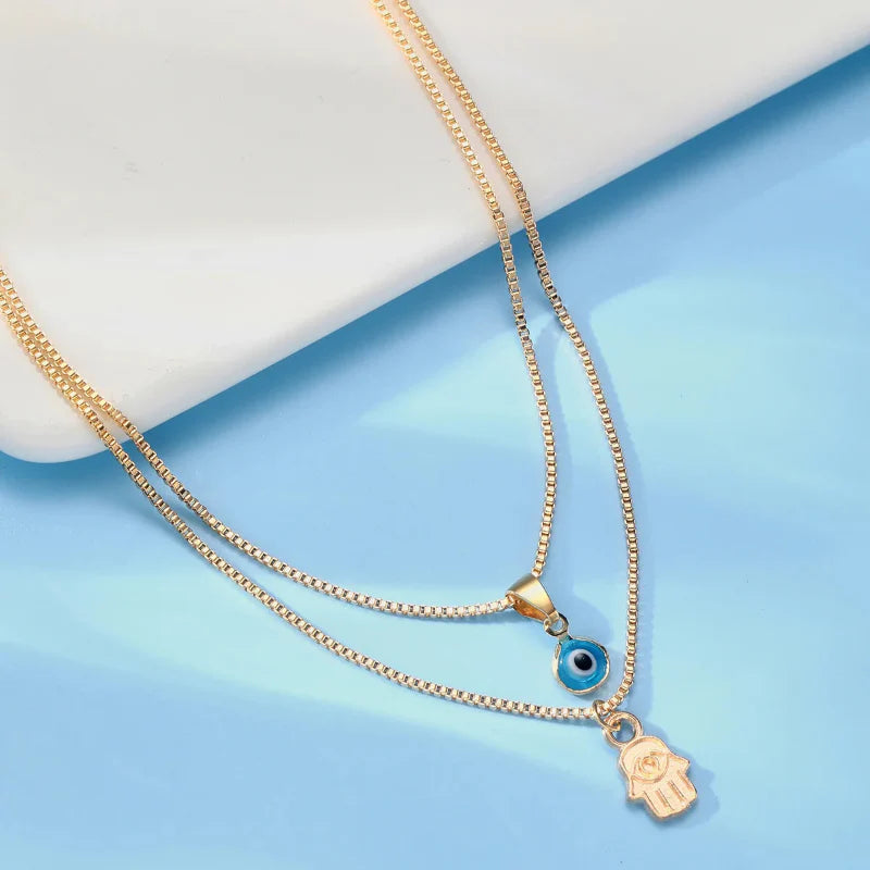 Double Necklace with Turkish Blue Eye and Fatima's Hand Pendant gold